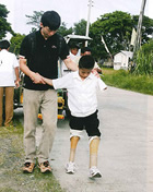 竹細工の義足をつけて歩行練習をするフィリピンの少年